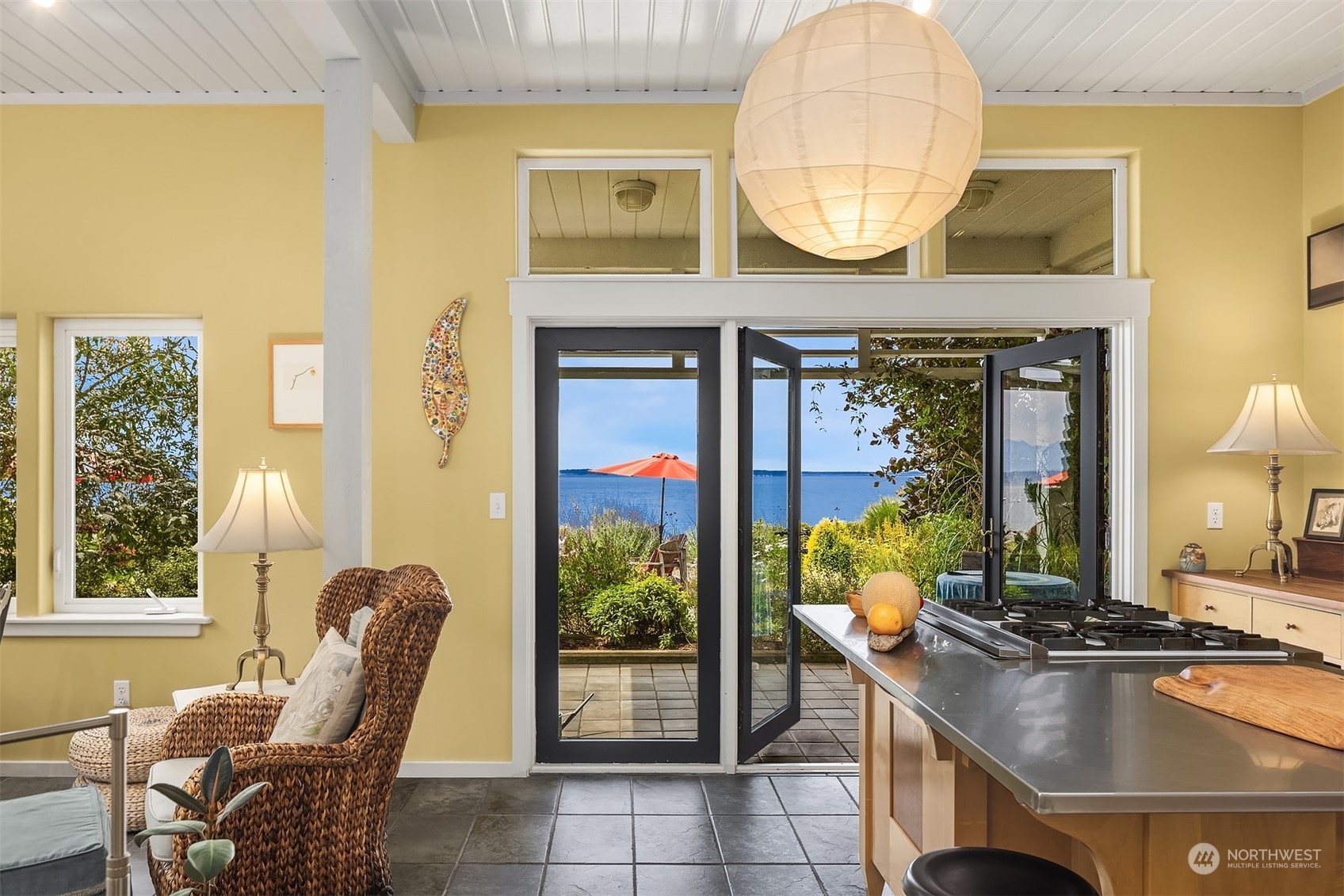 6346 South Bay Road Freeland, WA 98249 - Photo 12 of 40 a living room with furniture a fireplace and a floor to ceiling window