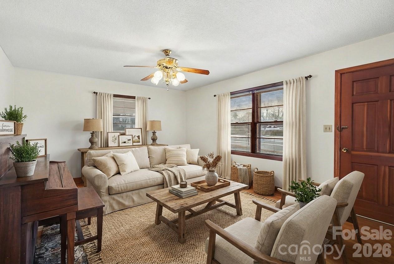 a living room with furniture a chandelier and a window