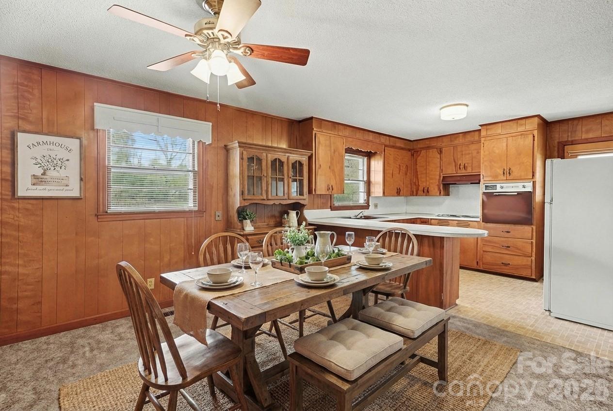 1612 Shelby Road, Unit 1417 Kings Mountain, NC 28086 - Photo 2 of 29 a dining room with stainless steel appliances kitchen island granite countertop a dining table chairs and a refrigerator