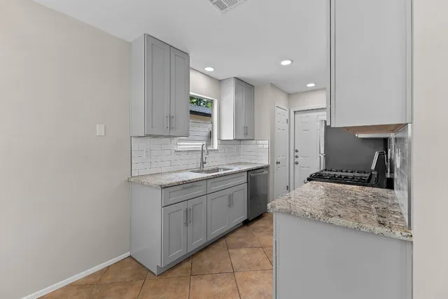 a large kitchen with kitchen island a sink stainless steel appliances and cabinets