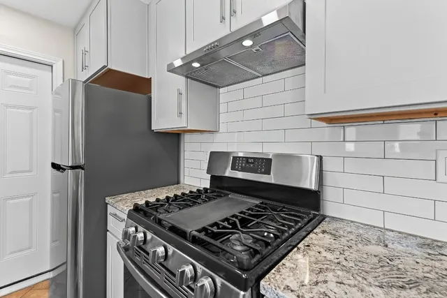 a stove top oven sitting inside of a kitchen