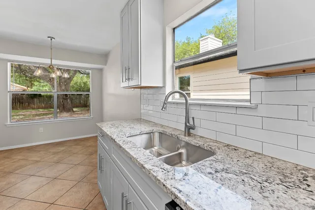 a kitchen with a sink a counter top space and cabinets