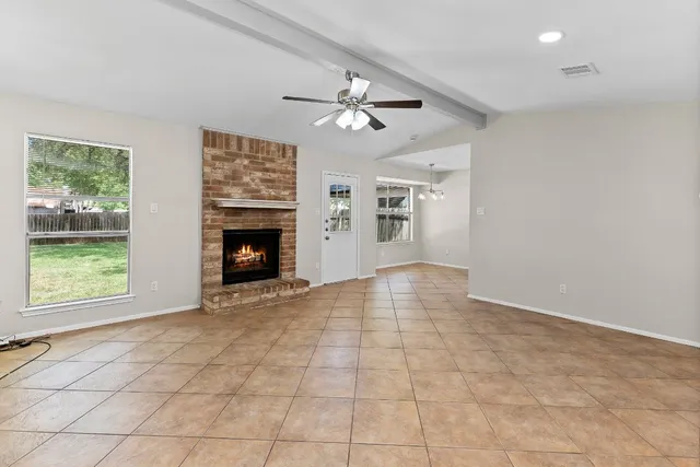 an empty room with windows and fireplace