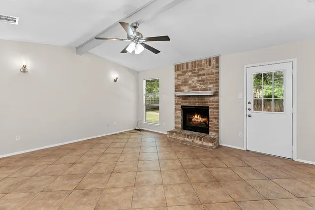 a view of an empty room with window and fireplace