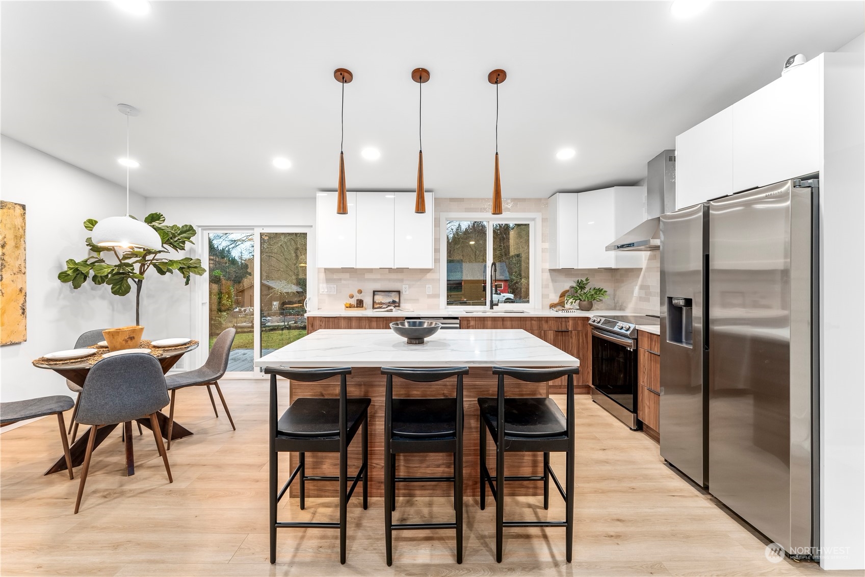 23033 192nd Avenue Southeast Renton, WA 98058 - Photo 13 of 40 a kitchen with stainless steel appliances kitchen island granite countertop a dining table chairs and a refrigerator