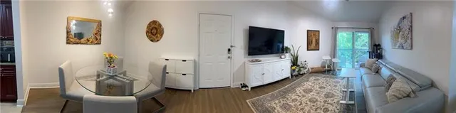 a view of a hallway with furniture and wooden floor