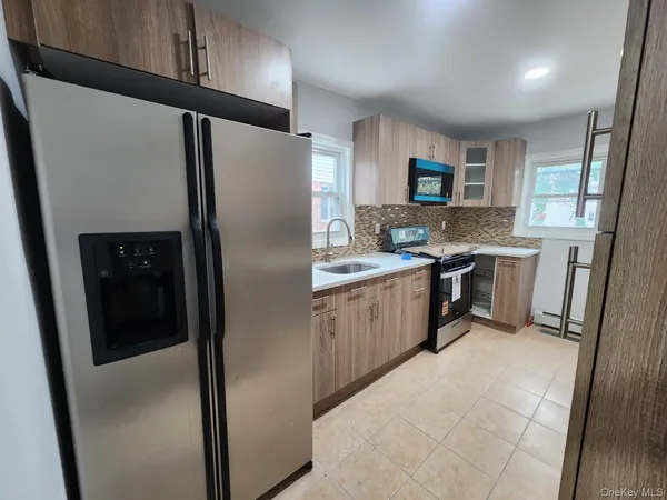 a kitchen with stainless steel appliances a refrigerator a sink a stove a microwave and island