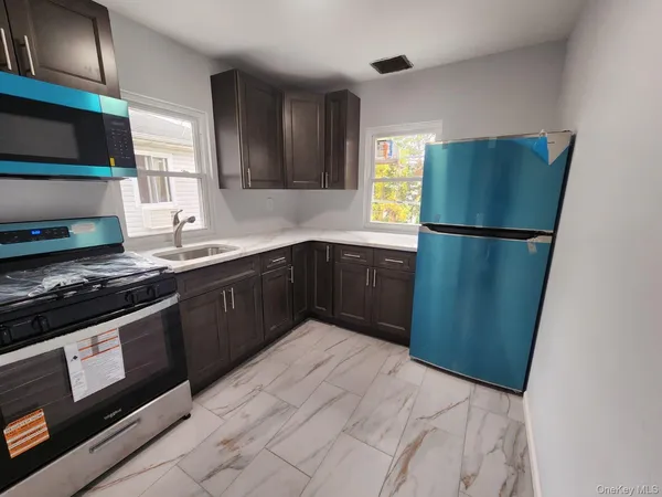 a kitchen with stainless steel appliances granite countertop a refrigerator a sink and a stove