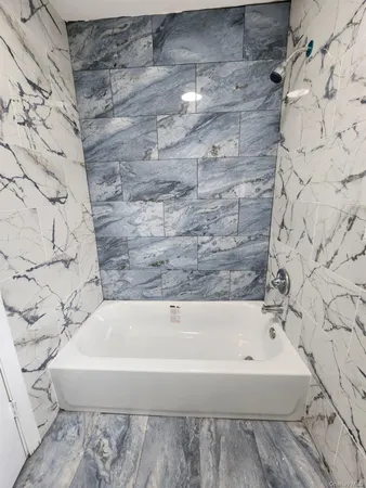 a bathroom with a bathtub and shower