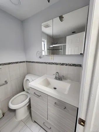 a bathroom with a sink a toilet and mirror
