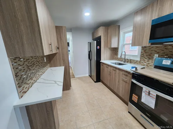 a kitchen with stainless steel appliances a stove a sink a refrigerator and cabinets