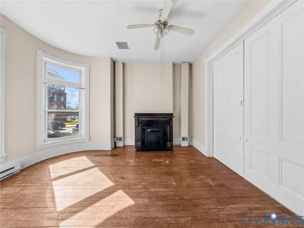 a view of a livingroom with wooden floor and a fireplace