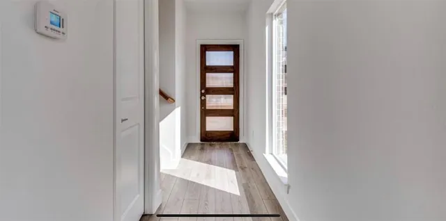 an entryway of a house with wooden floor and a window