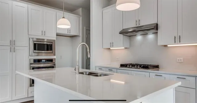 a view of a kitchen with a sink and dishwasher a refrigerator with wooden floor