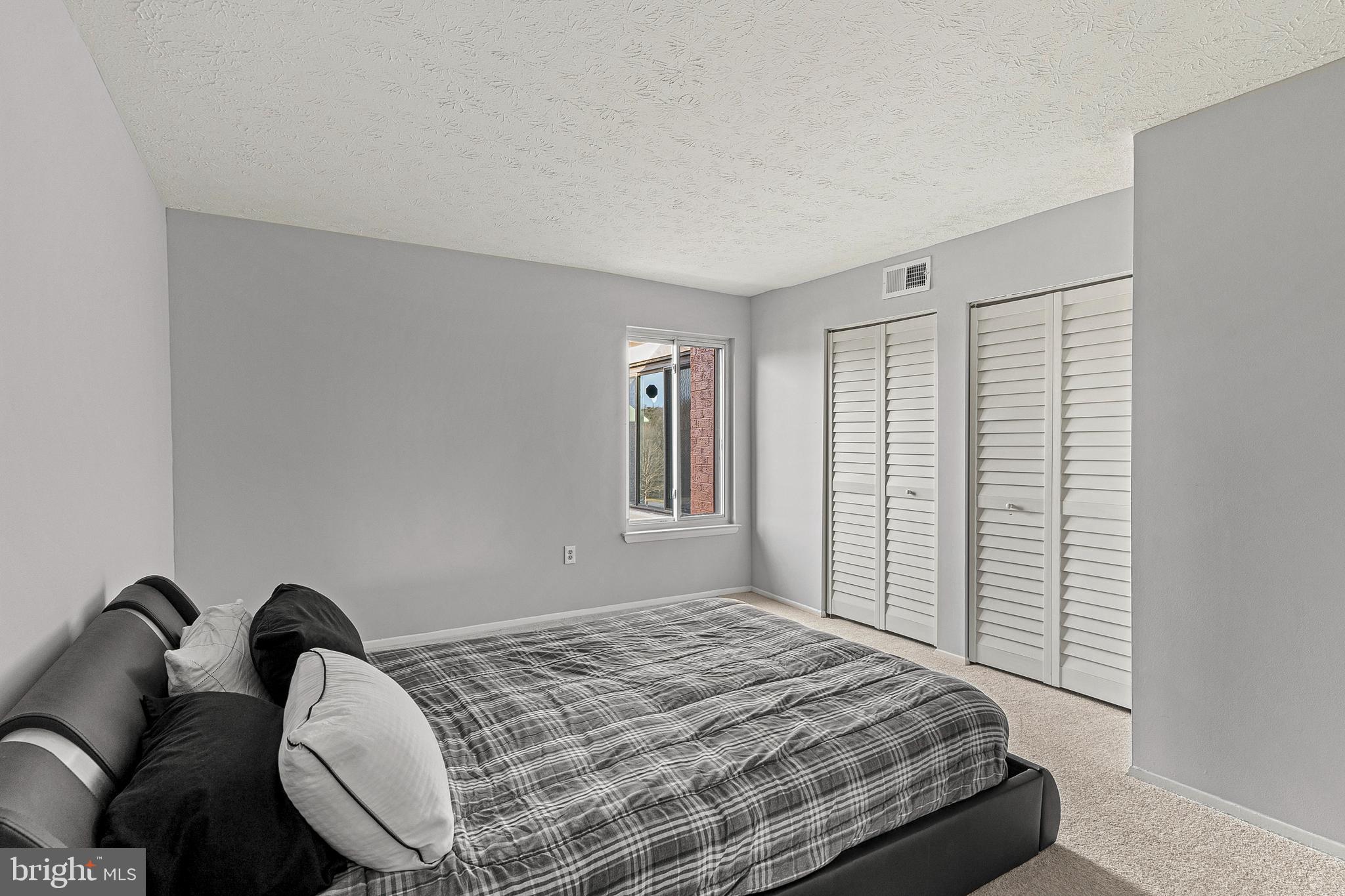 8005 Mandan Road, Unit 302 Greenbelt, MD 20770 - Photo 15 of 22 a bedroom with a bed couch and a window