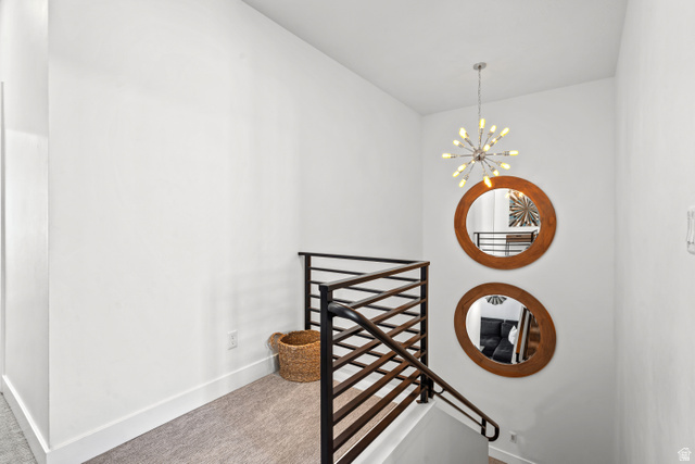 1122 South 1790th Street West, Unit 2 St. George, UT 84770 - Photo 12 of 37 Modern interior staircase featuring a contemporary metal railing, a stylish sputnik chandelier, and light gray carpeted flooring