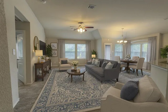 a living room with furniture and a dining table with wooden floor