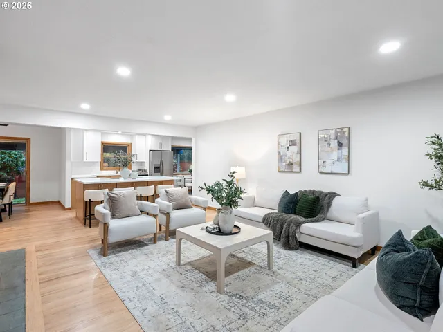a living room with furniture and view of kitchen
