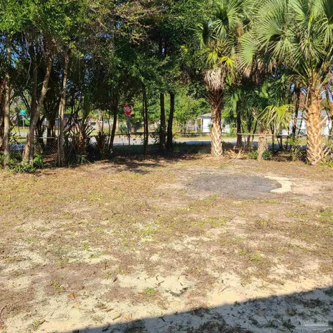 a view of a street with a building and trees in the background
