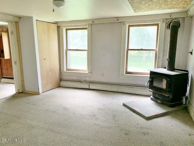 115 Lenox Road Richmond, MA 01254 - Photo 29 of 29 an empty room with windows a fireplace and wooden floor