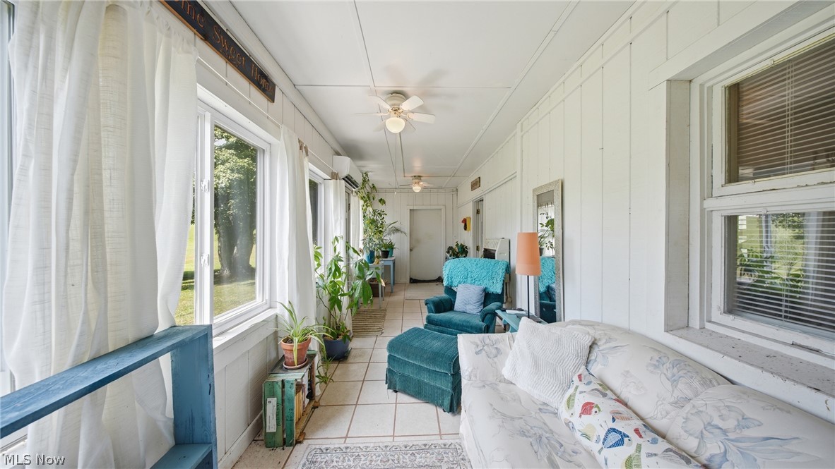89 Dagg Road Parkersburg, WV 26101 - Photo 24 of 45 Enclosed sunroom featuring multiple windows, board and batten walls, tiled flooring, and ceiling fans