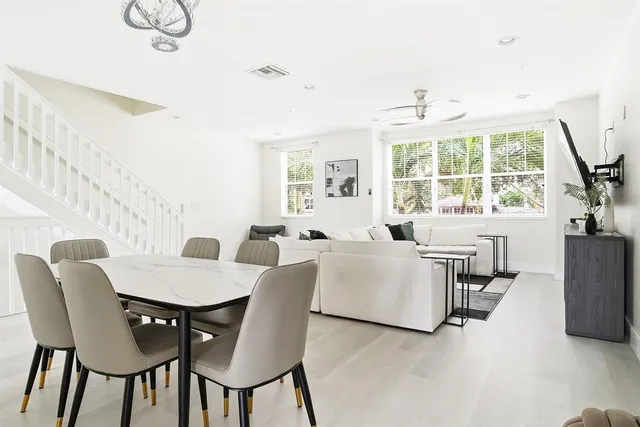 a view of a dining room with furniture a chandelier and wooden floor