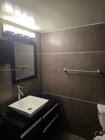 a bathroom with a sink a toilet and a mirror
