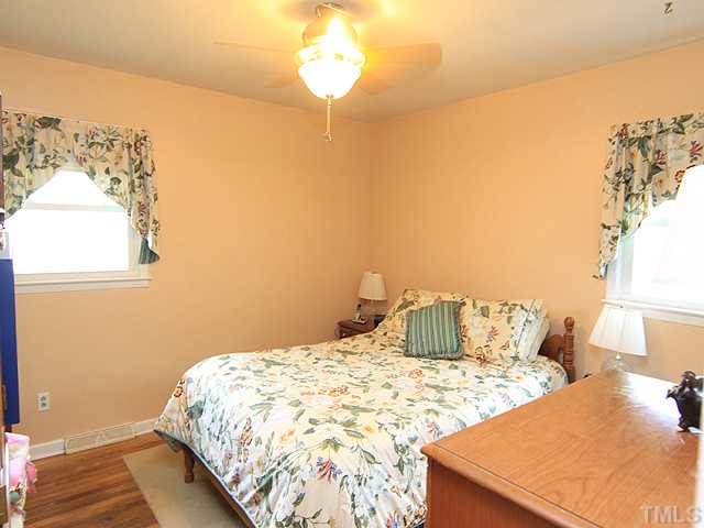1529 Clermont Road Durham, NC 27713 - Photo 6 of 12 a bedroom with a bed and a painting on the wall