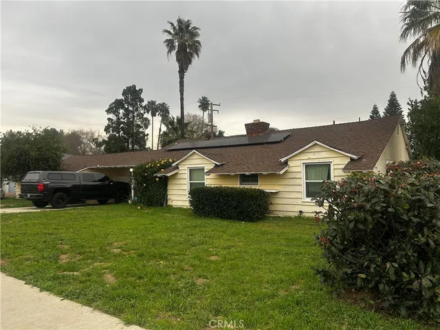 a front view of house with yard and car parked