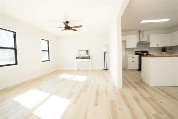 a kitchen with stainless steel appliances granite countertop a stove top oven a refrigerator a sink dishwasher and a fireplace with wooden floor