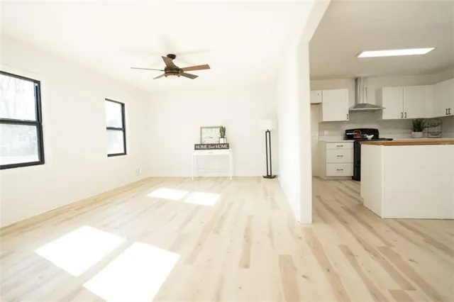 a kitchen with stainless steel appliances granite countertop a stove top oven a refrigerator a sink dishwasher and a fireplace with wooden floor