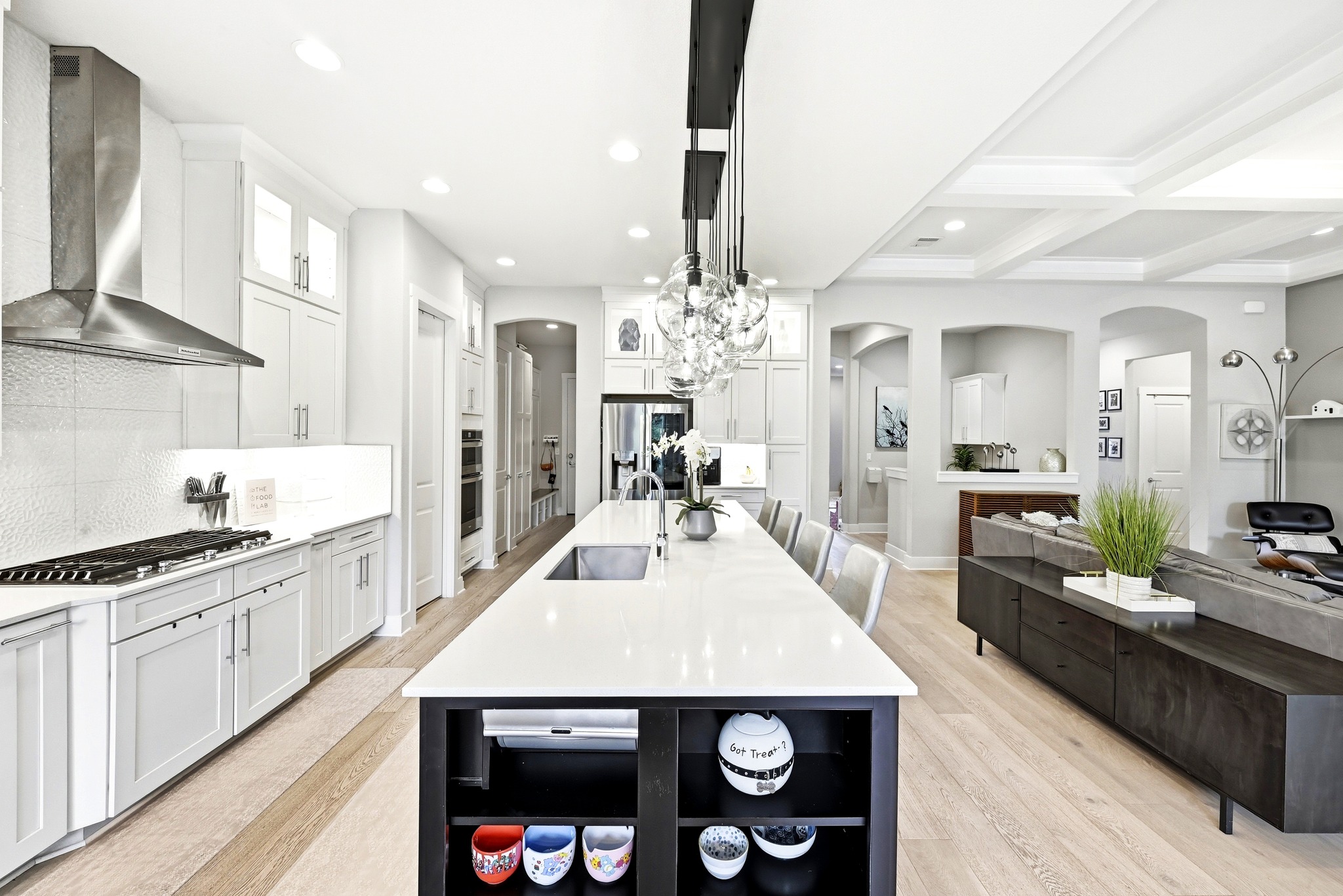 9008 Harper Rae Drive Austin, TX 78717 - Photo 13 of 39 Spacious kitchen featuring a large central island with seating, a stainless steel range hood, white cabinetry, and light wood-finish flooring