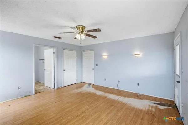 a view of a big room with closet and a ceiling fan