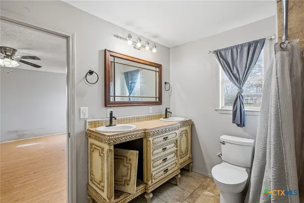 a bathroom with a granite countertop toilet sink and mirror
