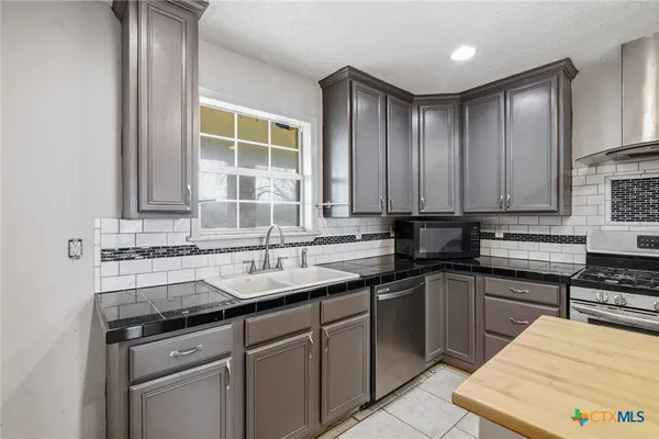 a kitchen with a sink stove and cabinets
