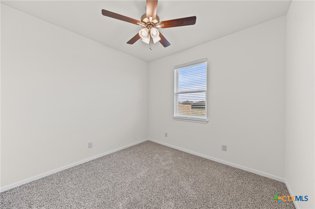 7806 Timber Holw Lane Temple, TX 76502 - Photo 20 of 30 an empty room with a chandelier fan and windows