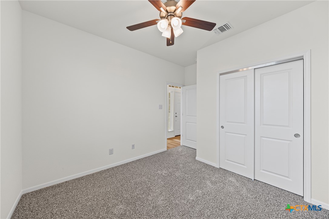 7806 Timber Holw Lane Temple, TX 76502 - Photo 21 of 30 an empty room with chandelier fan and closet area