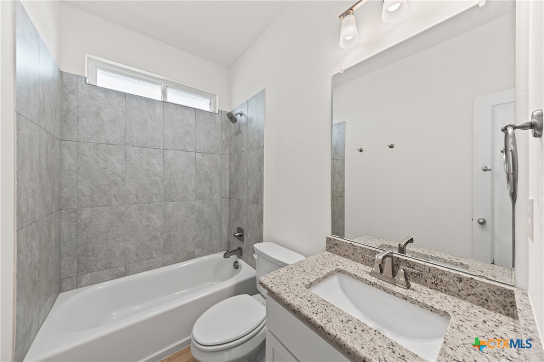 7806 Timber Holw Lane Temple, TX 76502 - Photo 22 of 30 a bathroom with a granite countertop tub sink toilet shower and mirror