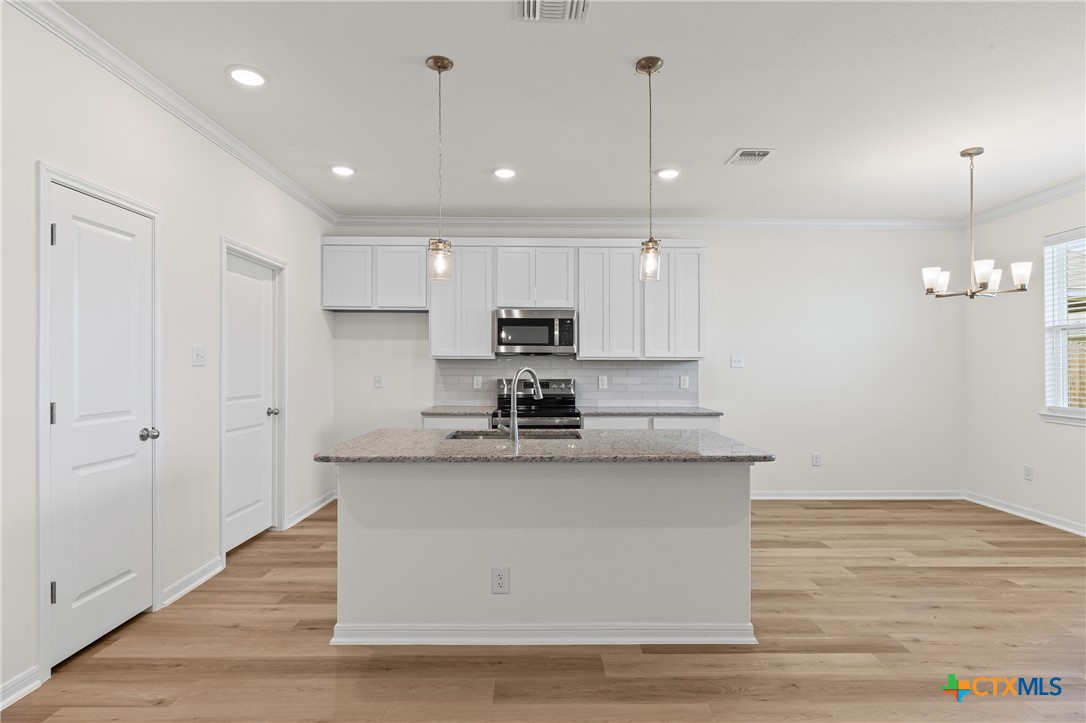 7806 Timber Holw Lane Temple, TX 76502 - Photo 8 of 30 a large kitchen with stainless steel appliances granite countertop a stove a sink and a refrigerator