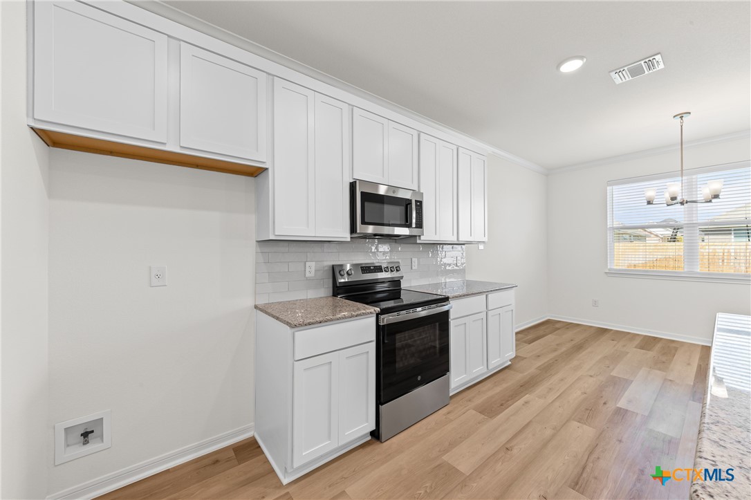 7806 Timber Holw Lane Temple, TX 76502 - Photo 9 of 30 a kitchen with granite countertop cabinets stainless steel appliances and a wooden floor