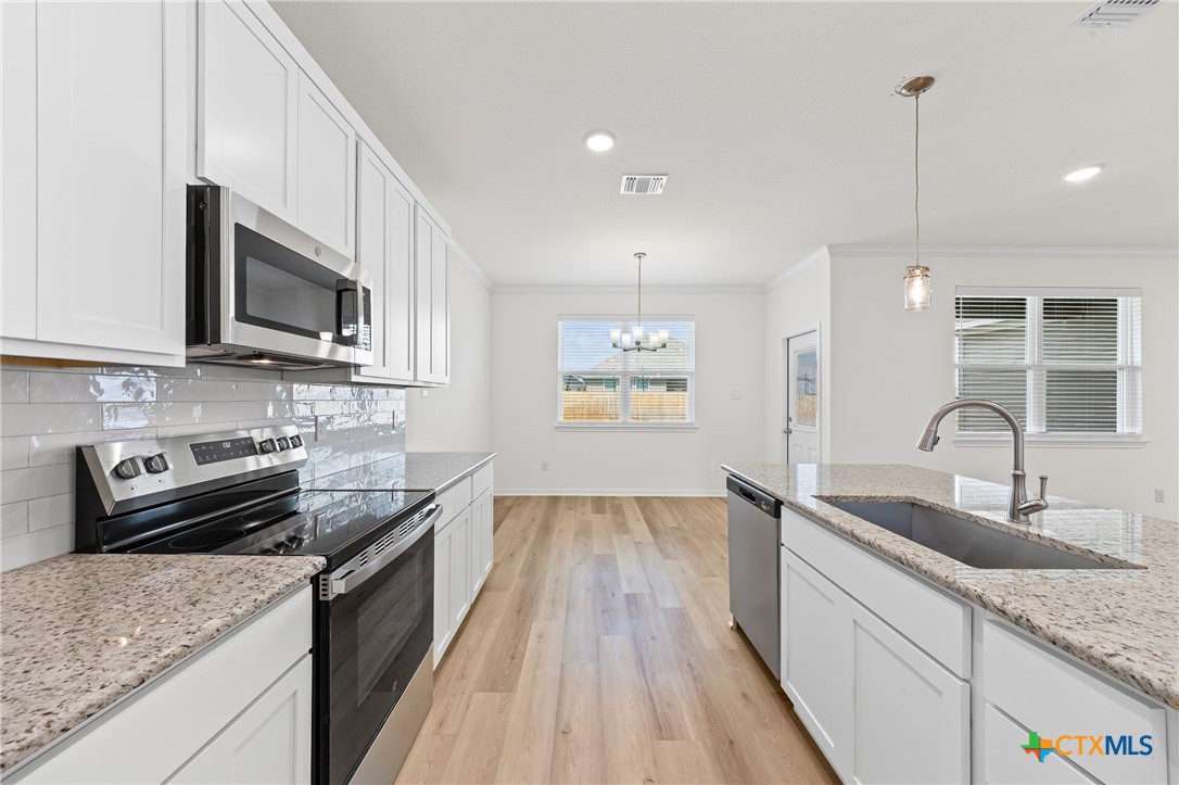 7806 Timber Holw Lane Temple, TX 76502 - Photo 10 of 30 a kitchen with stainless steel appliances granite countertop a sink stove and microwave