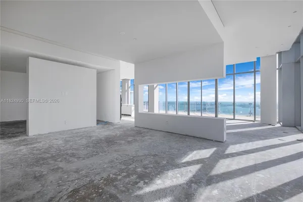 a view of an empty room with glass door and windows