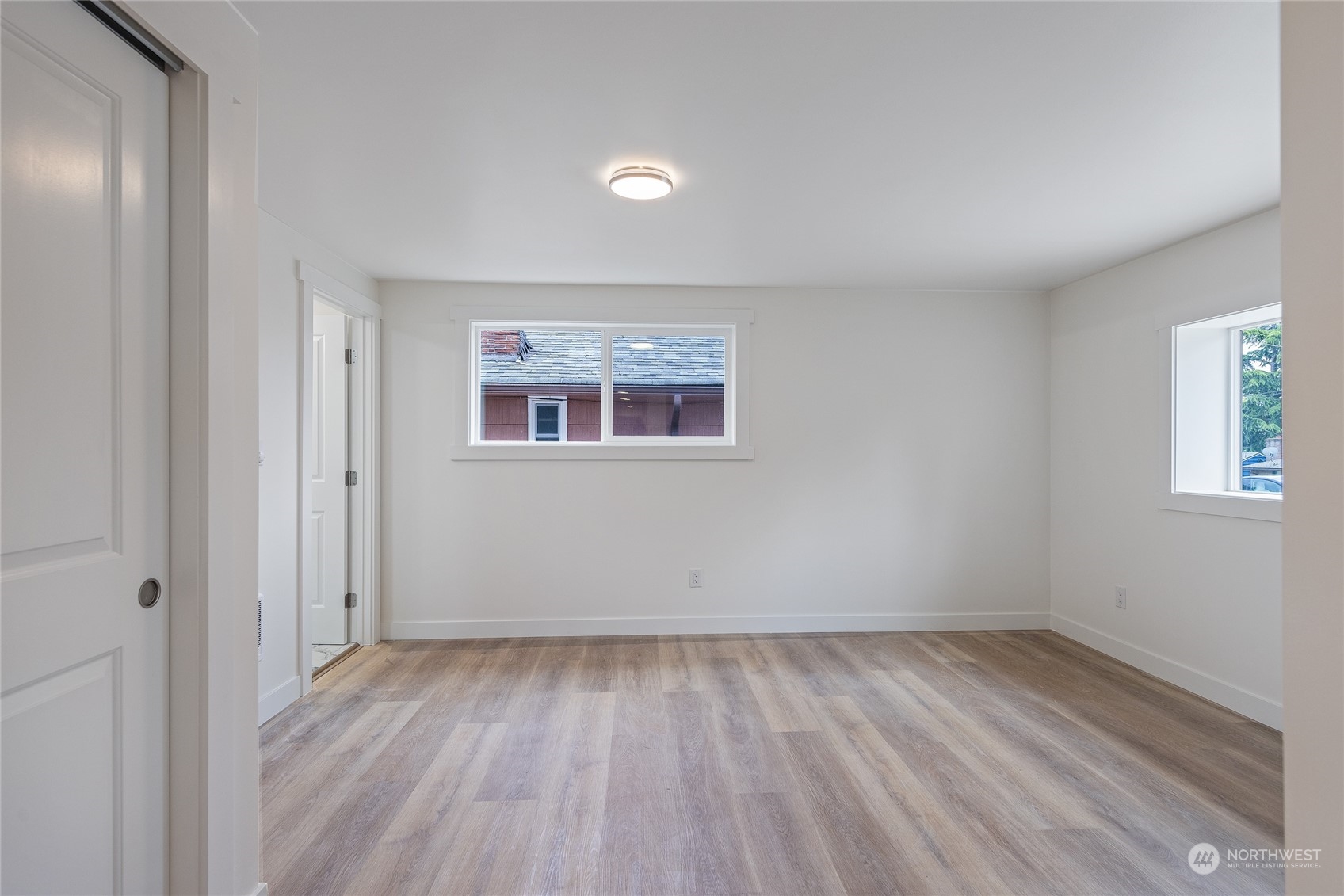 7614 South 113th Street Seattle, WA 98178 - Photo 20 of 24 an empty room with wooden floor and windows
