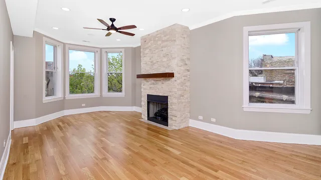 a view of an empty room with window and fire place