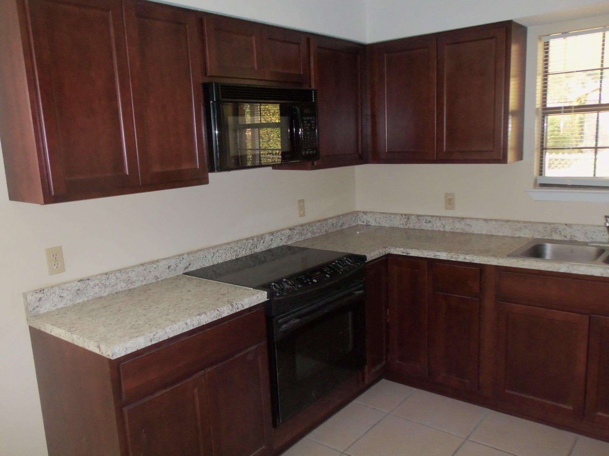 245 Elliott Road Mary Esther, FL 32569 - Photo 5 of 13 a kitchen with granite countertop cabinets and window
