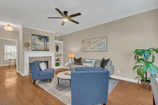 a living room with furniture a fireplace and wooden floor