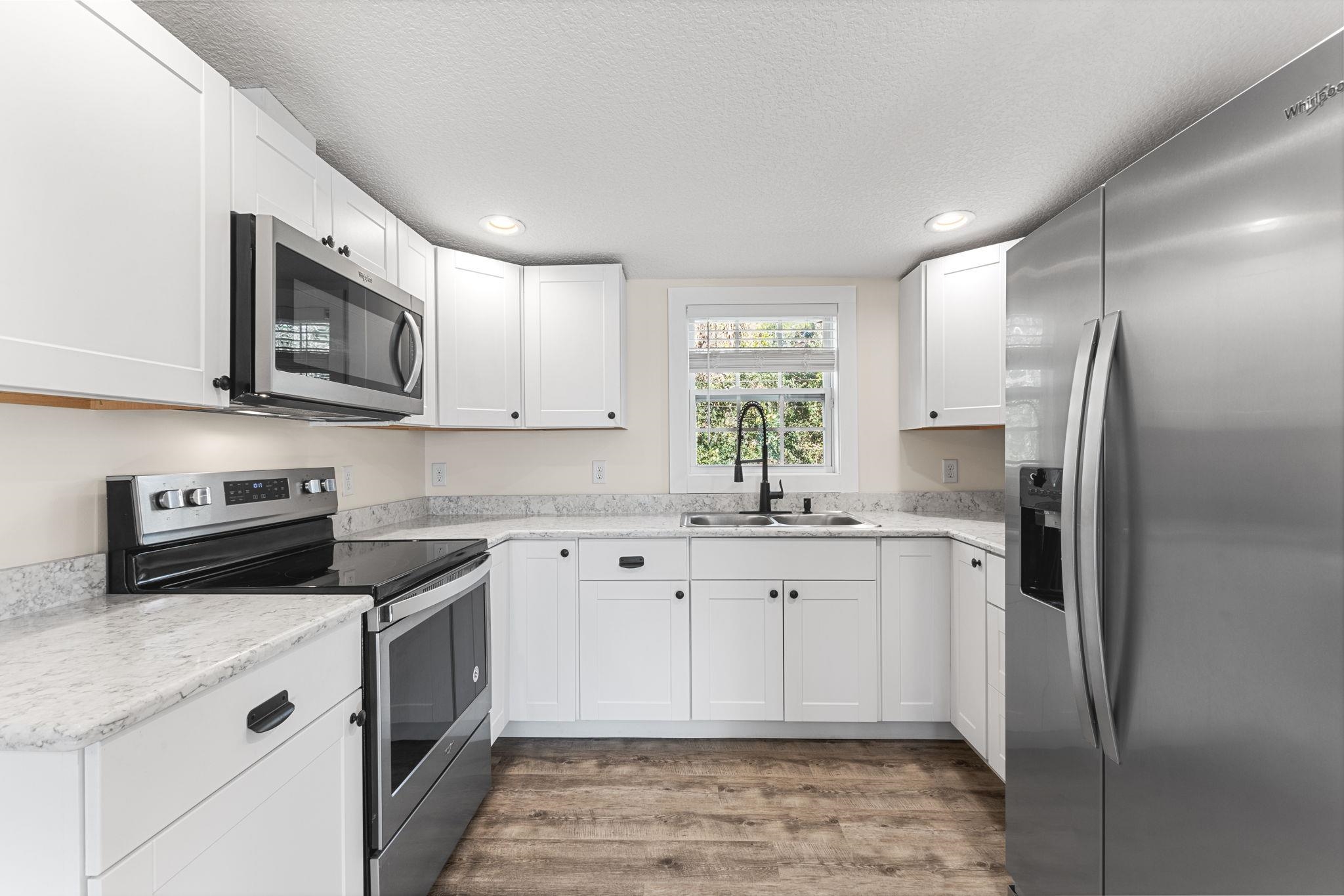 1385 Highland Boulevard St. Augustine, FL 32084 - Photo 11 of 47 a kitchen with stainless steel appliances granite countertop a refrigerator sink and microwave