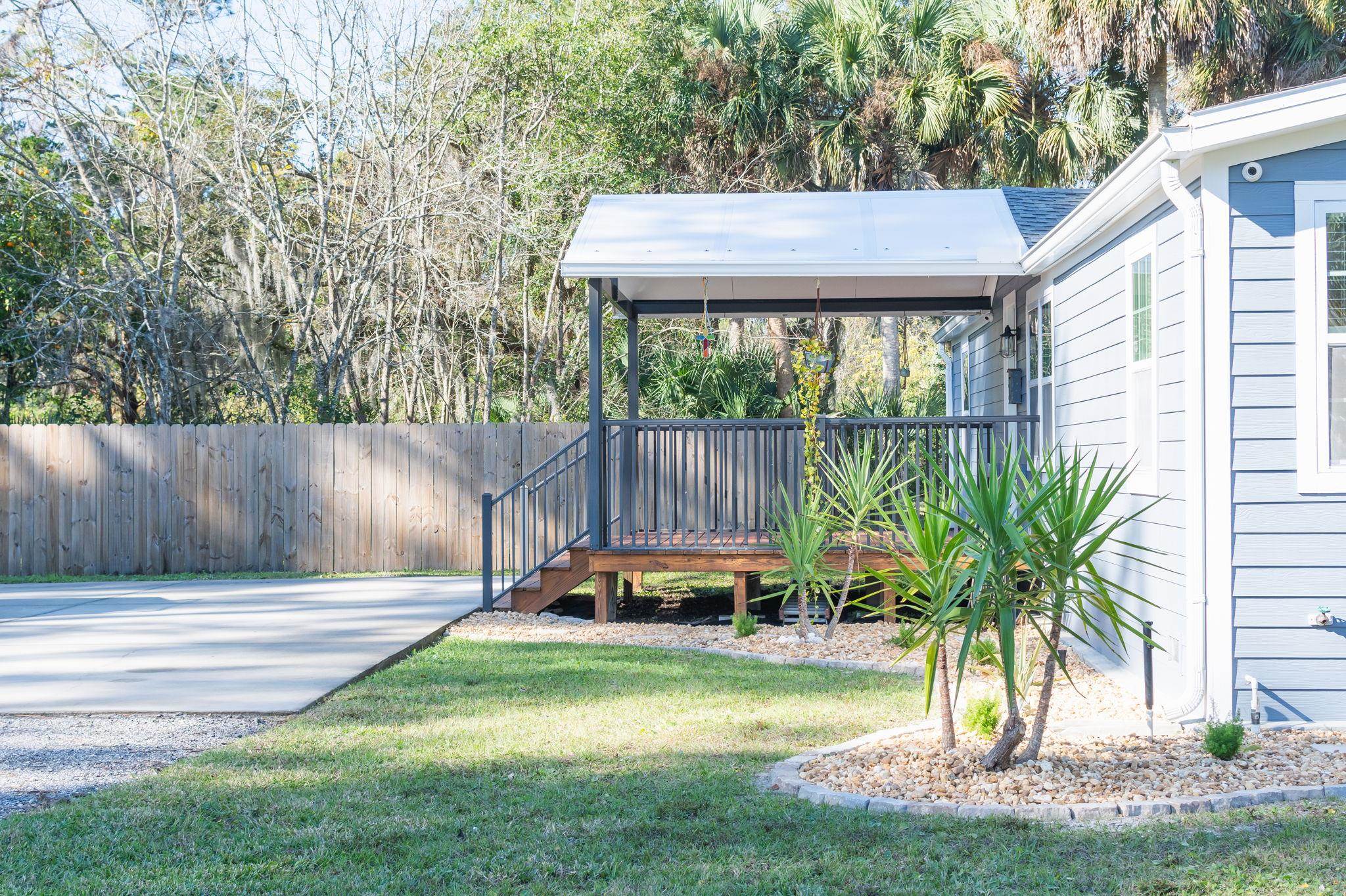 1385 Highland Boulevard St. Augustine, FL 32084 - Photo 3 of 47 a view of a backyard with couches plants and large trees
