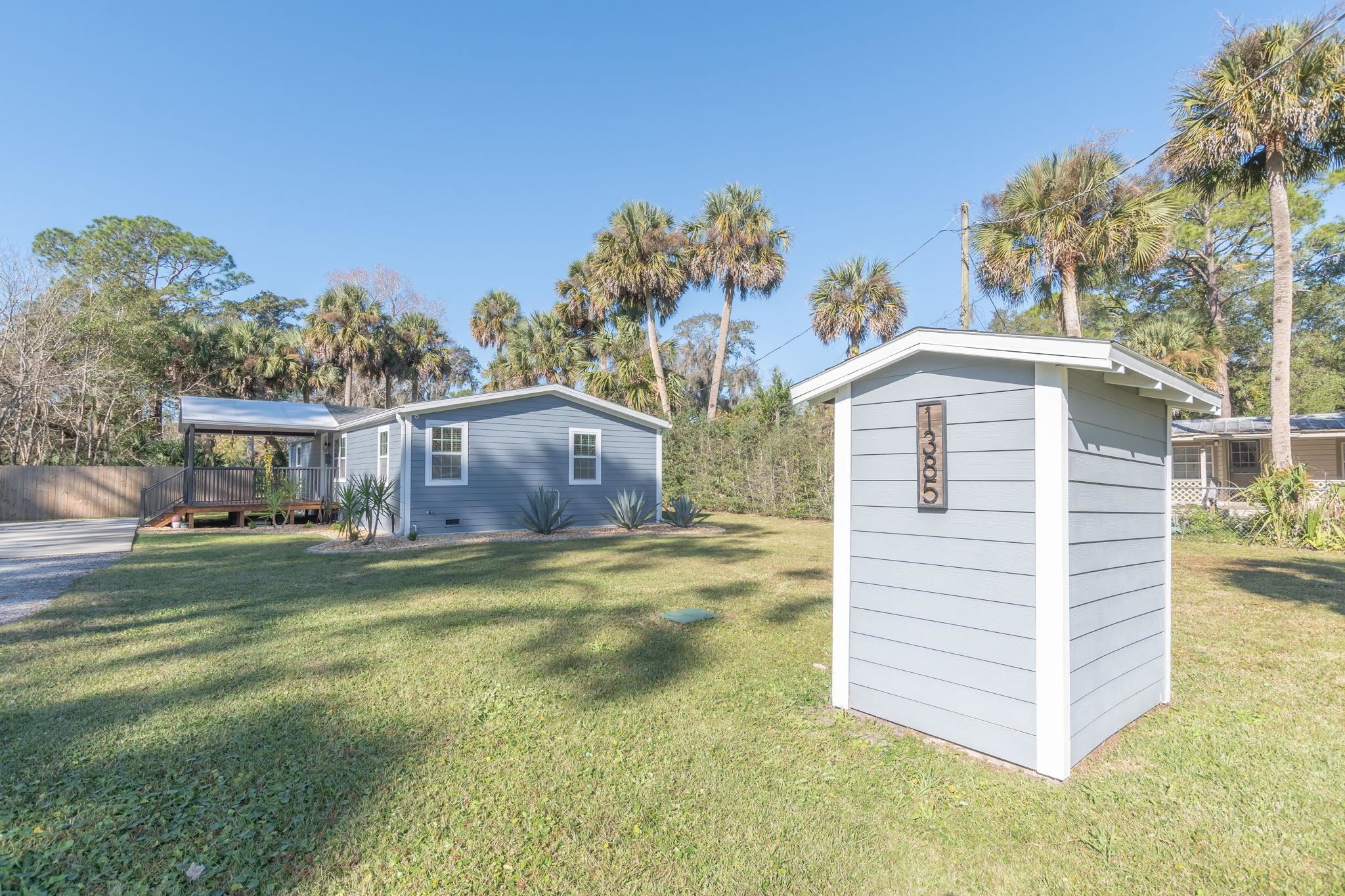 1385 Highland Boulevard St. Augustine, FL 32084 - Photo 43 of 47 a front view of a house with a yard and garage