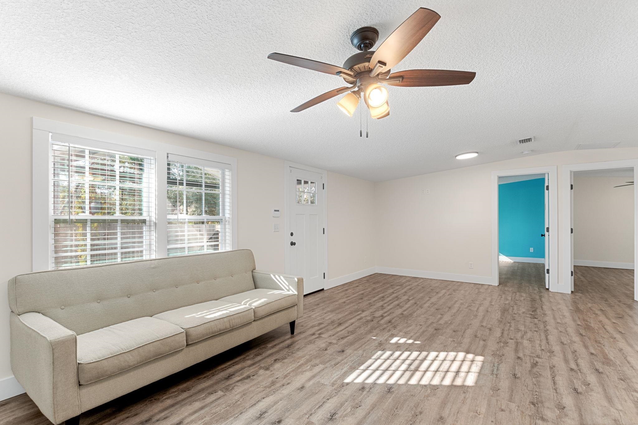 1385 Highland Boulevard St. Augustine, FL 32084 - Photo 9 of 47 a living room with couches and a large window with wooden floor